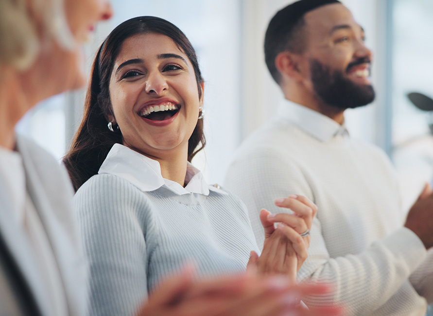People happily clapping at an event.